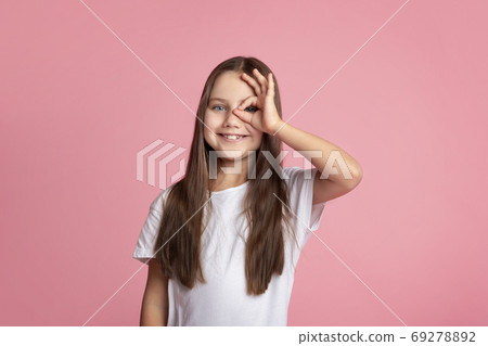 Everything is cool. Smiling kid doing ok sign with hand on eye looking through fingers Everything is cool. Smiling kid doing ok sign with hand on eye looking through fingers 69278892