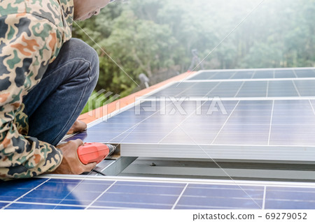 Close up man installing solar panels on a roof house for alternative energy photovoltaic safe energy. power from nature sun power solar cell generator save earth Close up man installing solar panels on a roof house for alternative energy photovoltaic safe energy. power from nature sun power solar cell generator save earth 69279052