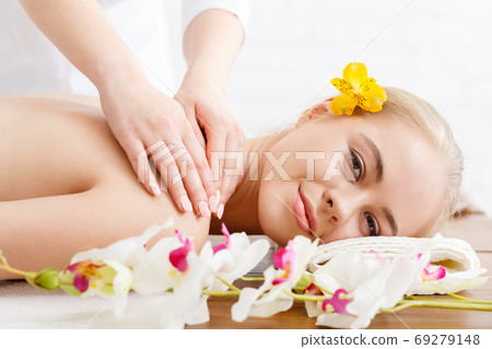 Relaxing in spa. Smiling girl lies on massage table Relaxing in spa. Smiling girl lies on massage table 69279148