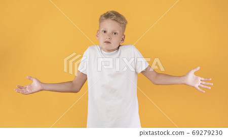 Confused puzzled male kid shrugging at studio Confused puzzled male kid shrugging at studio 69279230