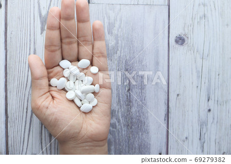 Close up of women hand taking pills Close up of women hand taking pills 69279382