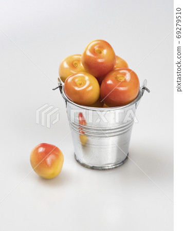 Berries of yellow cherry in a silver metal bucket and one near it. Isolated. Berries of yellow cherry in a silver metal bucket and one near it. Isolated. 69279510