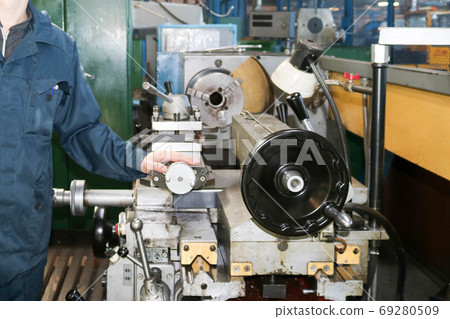 A man working in a robe, overalls stands next A man working in a robe, overalls stands next 69280509