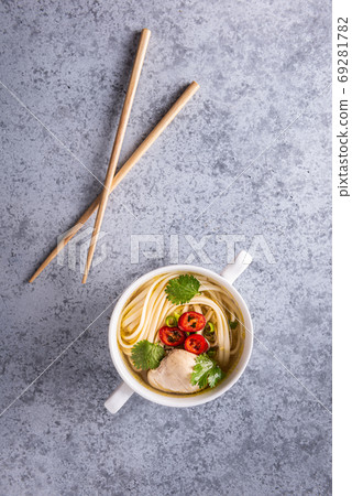 Spicy asian soup and wooden chopsticks on gray 69281782