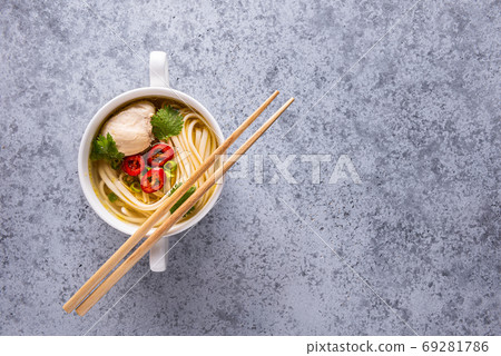 Gray backround with soup and chopsticks on bowl Gray backround with soup and chopsticks on bowl 69281786