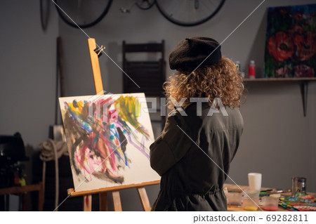 An artist in the process of drawing an abstract picture. Waiting for inspiration in the workshop. 69282811