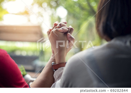 Young couples hold hands while sitting together at home, hands f 69282844