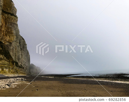 Misty morning fog landscape on the cliffs of Etretat in France Misty morning fog landscape on the cliffs of Etretat in France 69282856