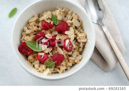 Oatmeal with raspberries, honey and almond petals. Healthy breakfast. 69283165