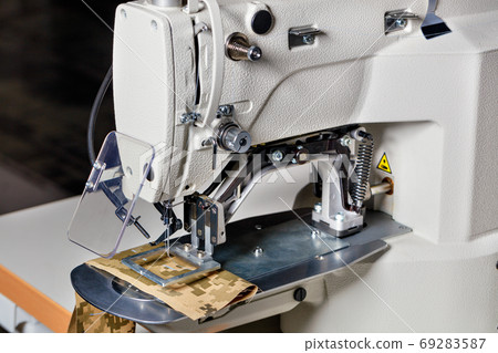 Professional overlock sewing machine, equipment for hemming and sewing clothes, close-up. Professional overlock sewing machine, equipment for hemming and sewing clothes, close-up. 69283587