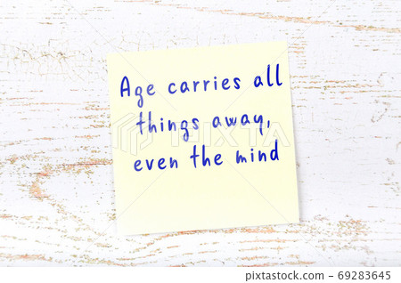 Wise quote on sticky note on wooden wall Wise quote on sticky note on wooden wall 69283645