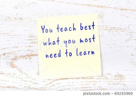 Yellow sticky note on wooden wall with wise quote Yellow sticky note on wooden wall with wise quote 69283960