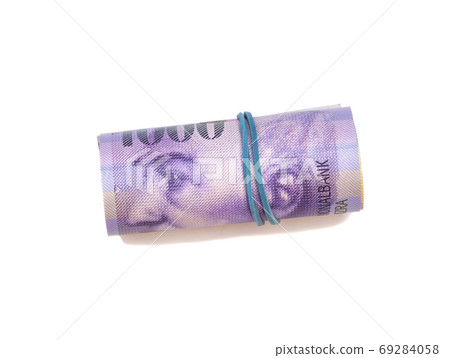 Swiss thousand francs in a roll on white background 69284058