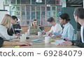 Business woman leader holds meet up with colleagues at a large office table in a loft style. Creative interior. Coworking startup team. Office workers 69284079
