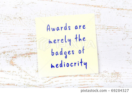 Yellow sticky note on wooden wall with wise quote Yellow sticky note on wooden wall with wise quote 69284327