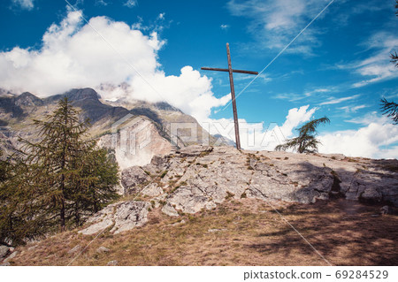 Alpine Cross. An alpine landscape containing a large wooden cross. Beautiful mountain landscape in Austria with blue sky 69284529