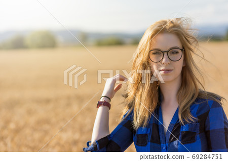 Cool young woman is posing in the wind outdoors. 69284751