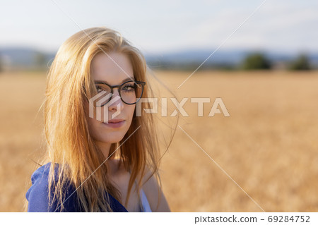 Portrait of young woman posing in corn field looking at the came 69284752