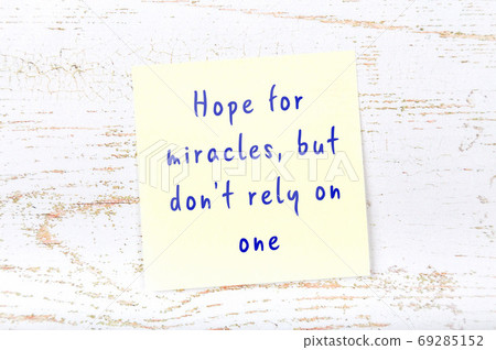 Yellow sticky note on wooden wall with wise quote 69285152