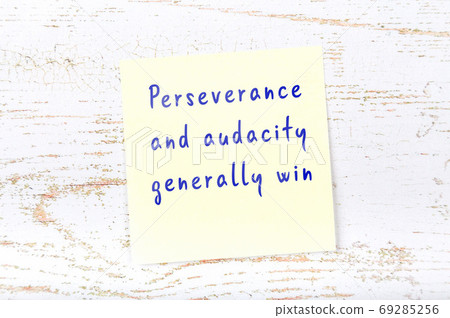 Yellow sticky note on wooden wall with wise quote Yellow sticky note on wooden wall with wise quote 69285256