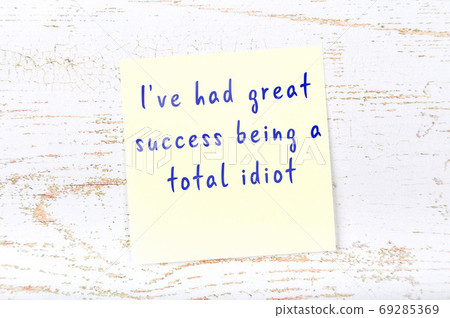 Yellow sticky note on wooden wall with wise quote 69285369