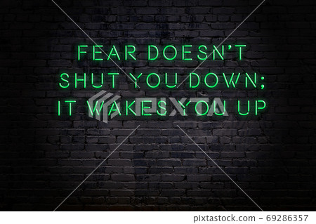 Wise quote. Neon inscription against brick wall 69286357