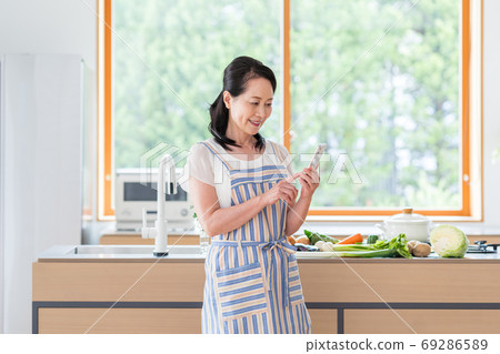Senior woman, kitchen, smartphone Senior woman, kitchen, smartphone 69286589