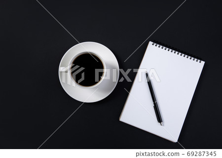 coffee cup and white notepad with pen on black background. top view coffee cup and white notepad with pen on black background. top view 69287345
