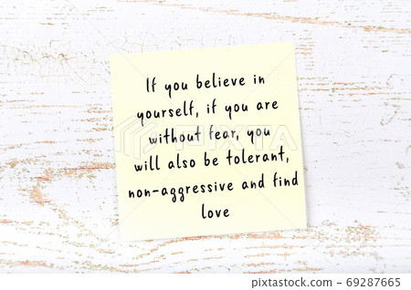 Yellow sticky note on wooden wall with wise quote 69287665