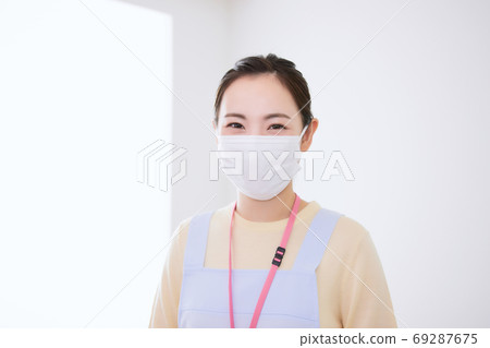 照顧者年輕女子戴著口罩 照顧者年輕女子戴著口罩 69287675