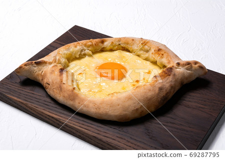 Adjarian Khachapuri on a brown board on a white background. Geor Adjarian Khachapuri on a brown board on a white background. Geor 69287795