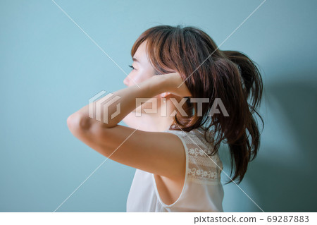 Asian woman brushing her hair Asian woman brushing her hair 69287883