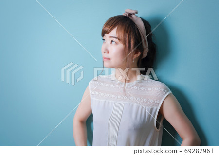 Woman in front of a blue wall Woman in front of a blue wall 69287961