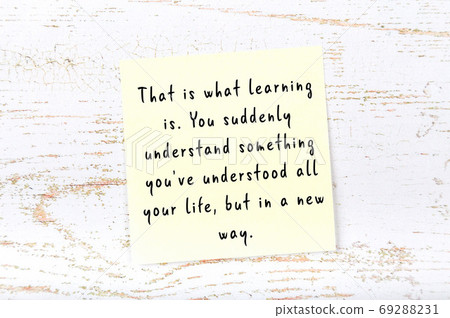 Yellow sticky note on wooden wall with wise quote 69288231
