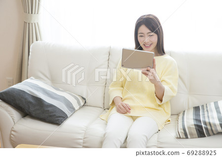 一個女人看著一台平板電腦 一個女人看著一台平板電腦 69288925