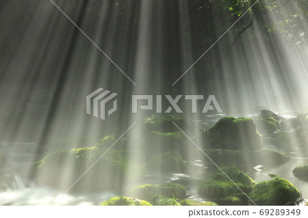 Summer waterfall underwater flowing in the rays of light Summer waterfall underwater flowing in the rays of light 69289349