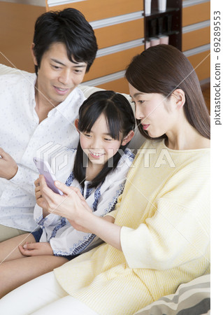 Family watching a smartphone Family watching a smartphone 69289553