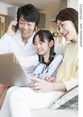 Family calling while looking at a computer Family calling while looking at a computer 69289581