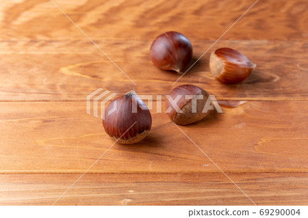 Chestnuts chestnuts lined up on a wooden table 69290004
