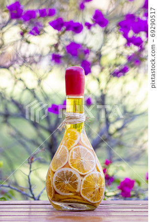Pickled orange slices in glass bottle, on wooden table 69290517
