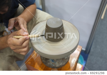 Concept Ceramic workshop. The man Throwing clay bowl on a pottery's wheel. 69291298