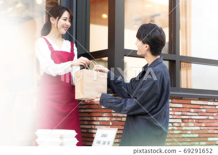 女售貨員和通過櫃檯銷售商品的顧客 69291652