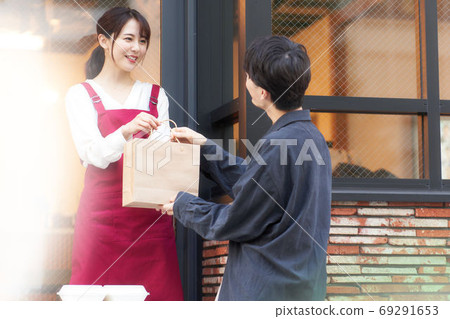 女售貨員和通過櫃檯銷售商品的顧客 69291653