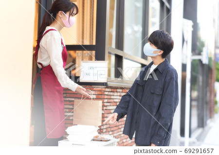 Saleswoman and customer wearing masks who sell over the counter 69291657