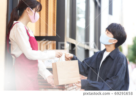 Saleswoman and customer wearing masks who sell over the counter 69291658