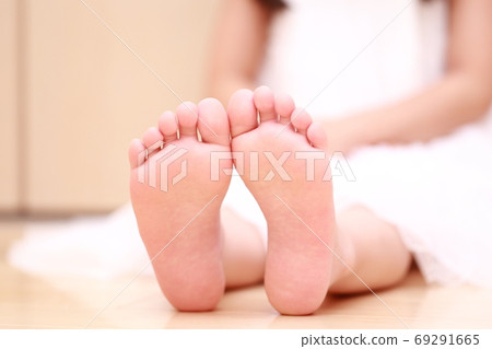 Barefoot girl sitting in a nightie 69291665