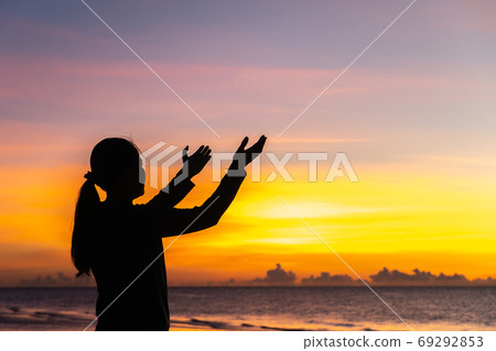 Silhouette of woman hands holding over beautiful 69292853