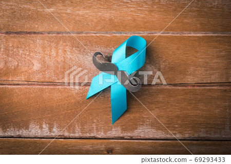 Light blue ribbon with a man mustache on wooden Light blue ribbon with a man mustache on wooden 69293433