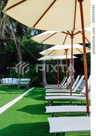 Image of Chaise longue at the pool in tropical resort Image of Chaise longue at the pool in tropical resort 69293485