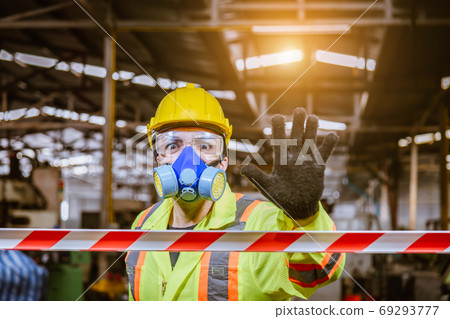Engineer industry wearing safety uniform ,black gloves and gas mask show hand signal no entry chemical dangerous area in industry factory work. 69293777